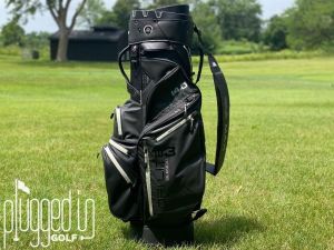 BIG MAX-Dri Lite Silencio 3-Cart Bag-pluggedingolf-testing-full bag vertical Picture of the BIG MAX Dri Lite Silencio 3 standing vertically in front of a fairway.