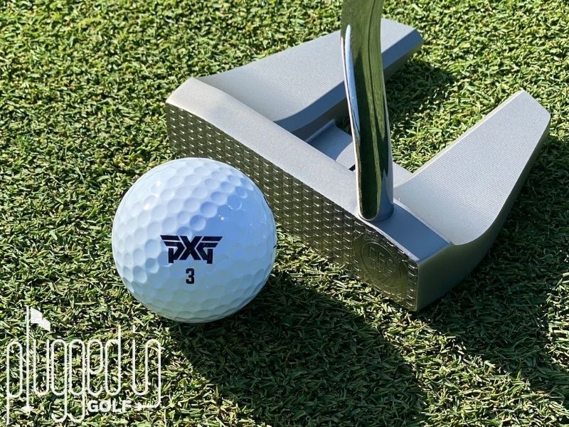 Picture of The Detroit Putter Co. The Ambassador and its DPC signature milled face on the green with a golf ball.