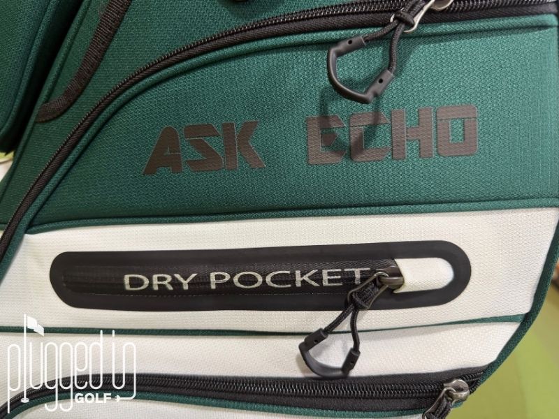 Picture of the Dry Pocket storage, wordmark, and zippers on the Ask Echo T-Lock 4.0 Cart Bag.